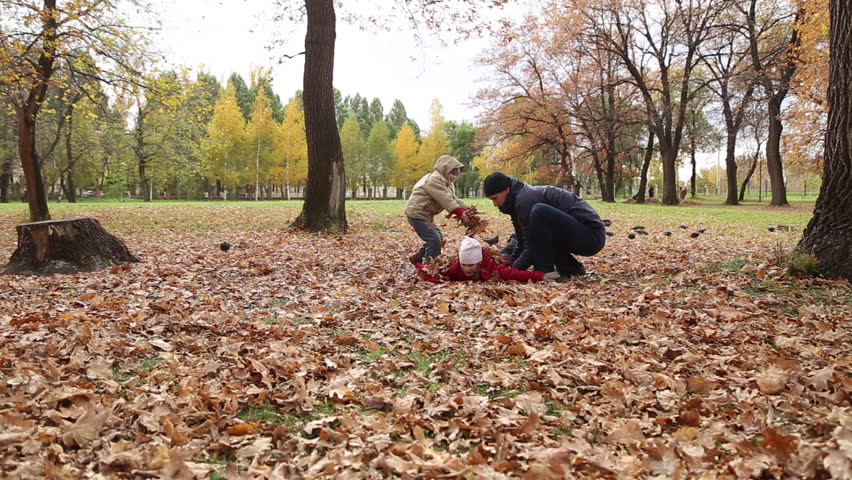 NOVOKUIBISHEVSK, SAMARA REGION/RUSSIA - OCTOBER 11: Father playing with daughter and son in autumn park on the fallen leaves, they imitating the planes on October 11, 2016 in Novokuibishevsk