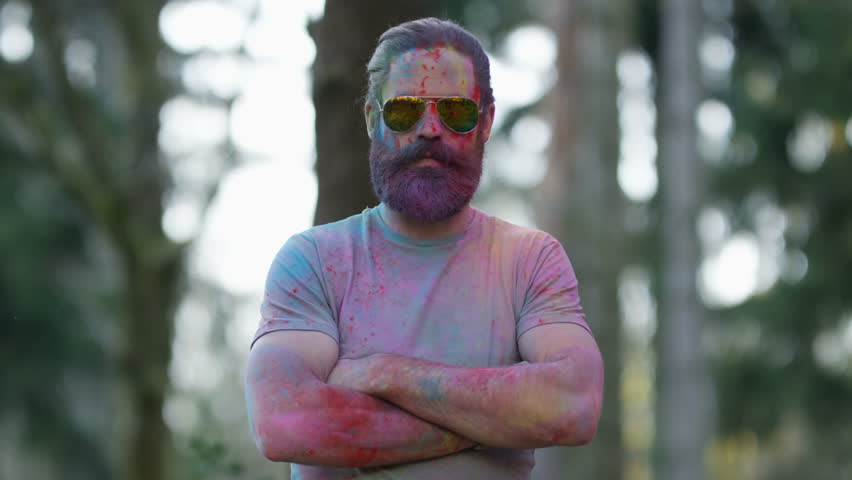 4K Portrait of serious hipster guy standing still while being covered in coloured powder at festival. Shot on RED Epic. | Shutterstock HD Video #20354965