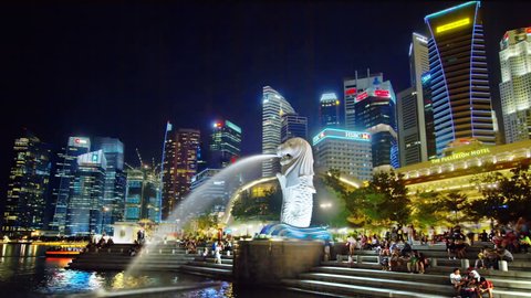SINGAPORE - OCTOBER 6,2016:  At night, the lion statue is a mythical creature as a landmark and a popular tourist attraction with many visitors.Time lapse