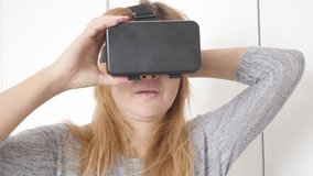 First time virtual reality glasses experience for blonde female in white space 4K 2160p 30fps UltraHD footage - Blond woman wearing 3D VR smart phone set 3840X2160 UHD video