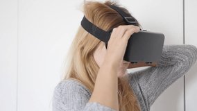 Slow motion of blond woman wearing 3D VR smart phone set 1920X1080 HD footage - Blonde female experiencing for the first time virtual reality glasses in white space  slow-mo 1080p FullHD video
