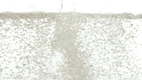 Water falling into surface on white background slow motion HD video. Water splash with bubbles and waves.