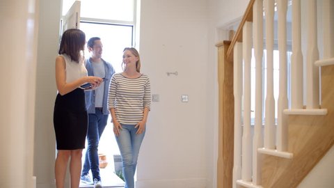 Realtor Showing Young Couple Around Property For Sale