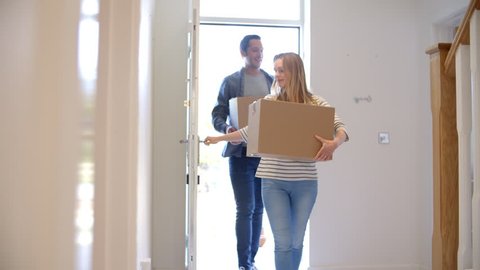 Couple Carrying Boxes Into New Home On Moving Day