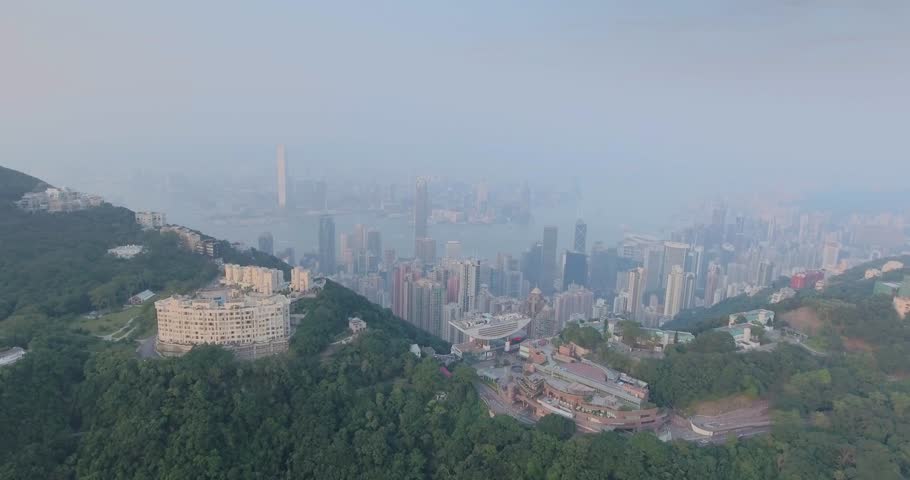 Beautiful aerial shot of many high  skyscrapers covered with sunset fog or haze in Hong Kong, China. Top view of Victoria Harbour and downtown from Victoria Peak at sunset. City skyline. | Shutterstock HD Video #20365795