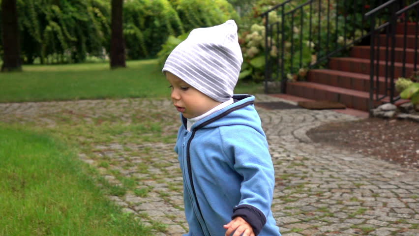 Baby boy is running at the garden near home, slow motion
