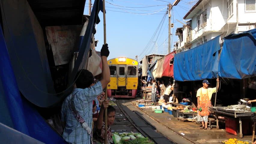 MAEKLONG, THAILAND - FEBRUARY 25, 2012: A train is going through the Maeklong