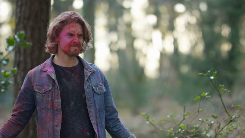 4K Portrait of happy high energy guy throwing coloured powder at festival. Shot on RED Epic.