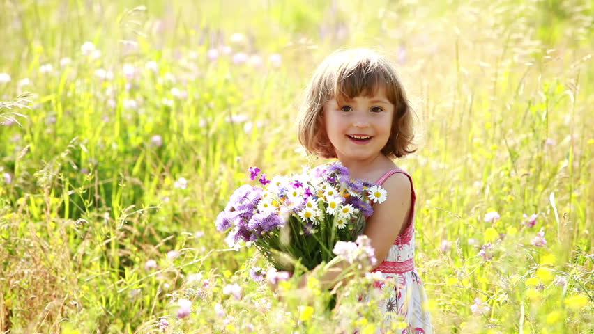 Little girl with flowers in a field