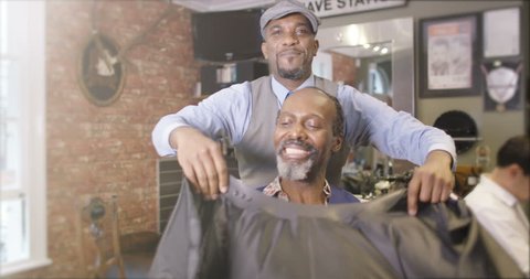 4K Friendly barber working on a customer in traditional retro barber shop. Shot on RED Epic. స్టాక్ వీడియో
