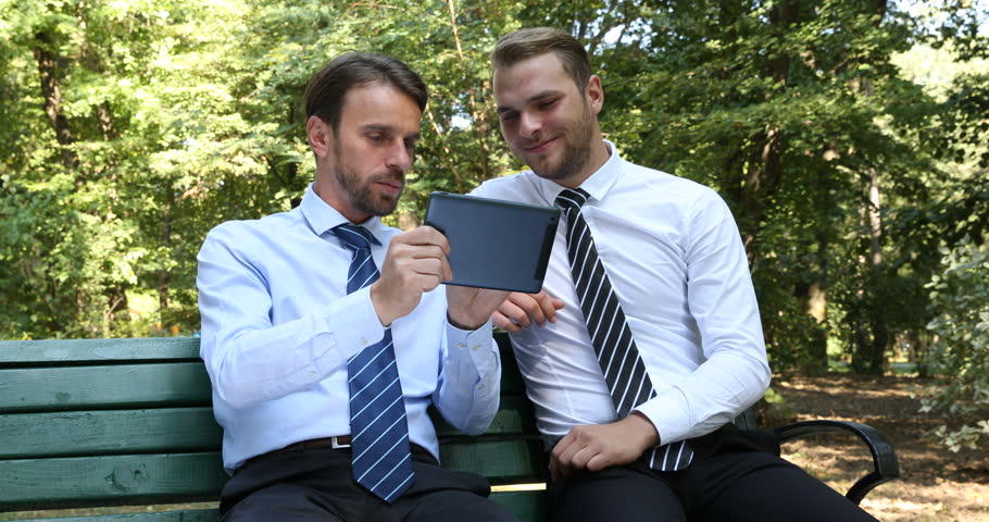 Business Men Presentation Work on Tablet Sitting a Park Bench near Green Trees. Ultra High Definition, UltraHD, Ultra HD, UHD, 4K, 2160P, 4096x2160