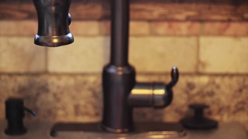 A man fills up a glass at the faucet