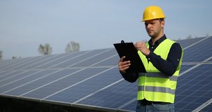 Electricity Engineer Man Holding Clip Board Taking Notes Looking Solar Panels. Ultra High Definition, UltraHD, Ultra HD, UHD, 4K, 2160P, 4096x2160