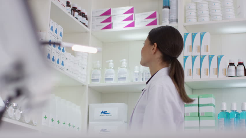4K Worker in a pharmacy putting a bottle of natural medicine onto shop counter. Shot on RED Epic. | Shutterstock HD Video #20404021