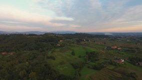 Aerial shot, gorgeous landscape on the sunset, smoke in the middle, in the middle of the plain, made with drone with the sun flare