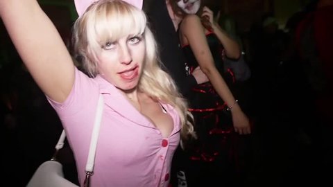 SAINT PETERSBURG, RUSSIA - OCTOBER 31, 2015: Sexy girl in pink nurse costume at Halloween party in nightclub. Erotic dance, drops of blood. Slow motion