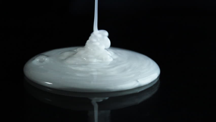 White cream is poured on a black background