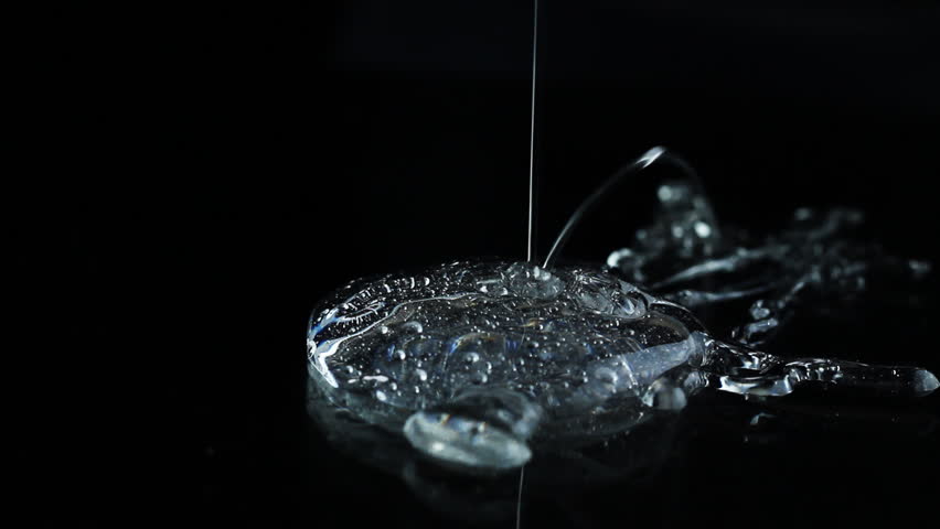 transparent cream is poured on a black background