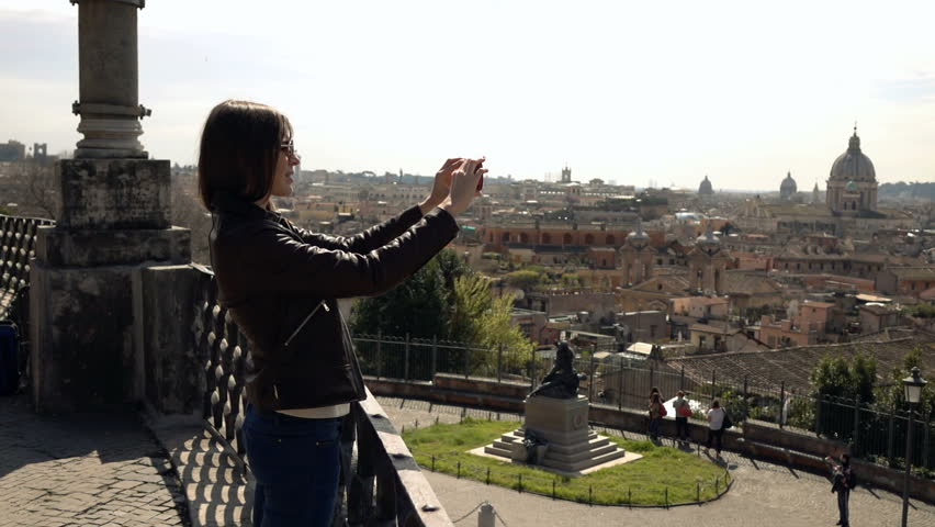 Woman taking photo of old town with cellphone, super slow motion 240fps
