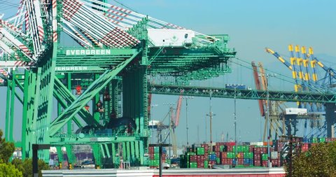 LOS ANGELES, CALIFORNIA, USA - OCTOBER 8, 2016: Trucks move cargo containers on the bridge at the sea port on October 8, 2016 in Los Angeles, California, 4K, from RAW