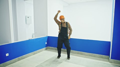 Single construction worker in room dancing fun