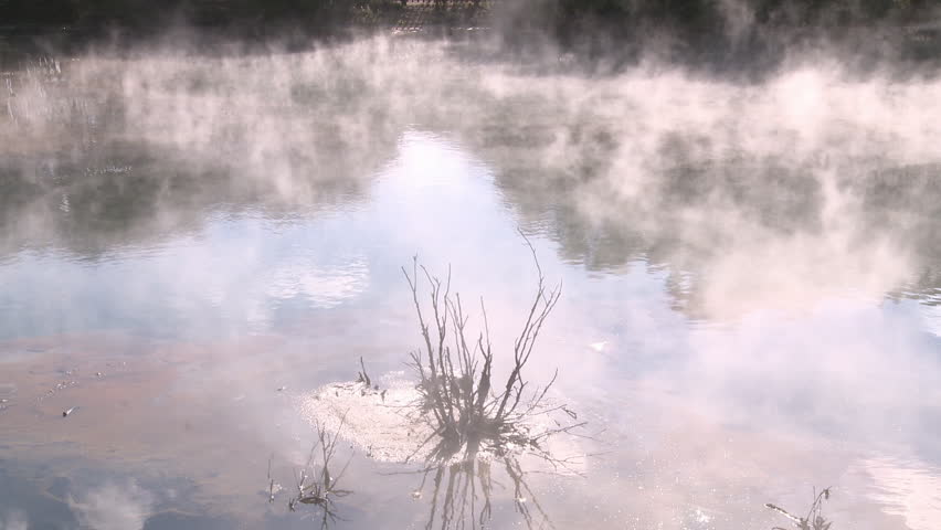 Steam rises off a geothermal pond.