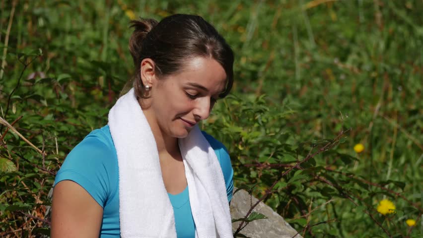 beautiful sporty girl texting on cellphone in nature