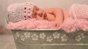 lovely sleeping newborn in pink hat and blanket in cot