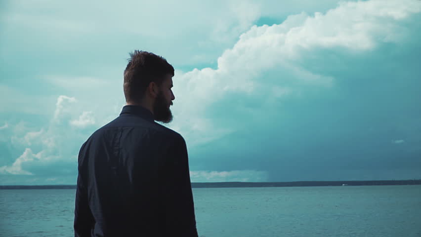 Young stylish man with a beard smokes an electronic cigarette in the background of the sea and clouds epic. Modern fashion vaping | Shutterstock HD Video #20455072