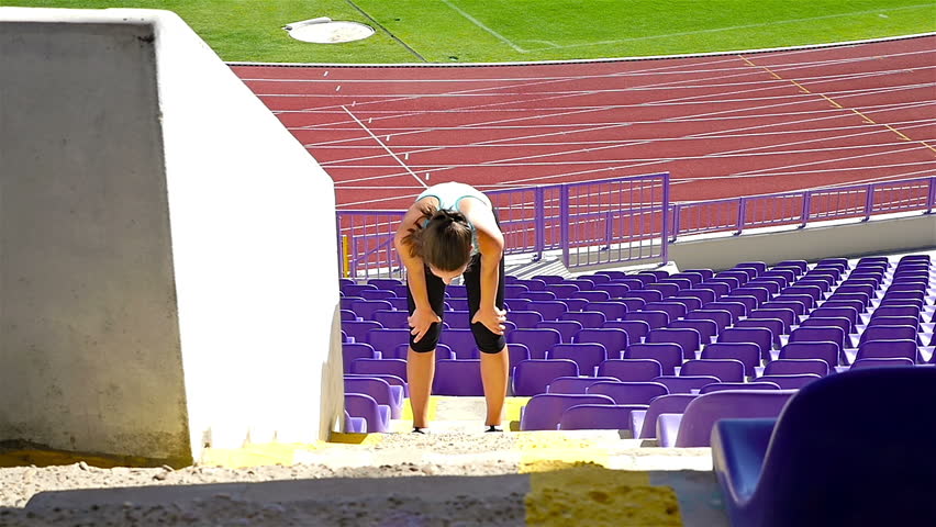 Woman girl athlete running up the stairs in a stadium, slow motion
