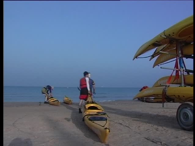 A man pulls canoe to the sea