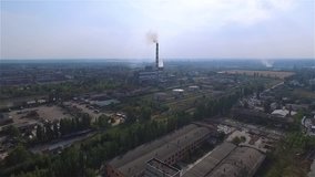 Flight over urban industrial area landscape HD aerial video: thermal power station, storages, plants, factories, cooling tower, pollution gas, flue-gas stack