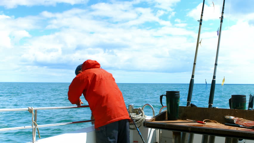 Fisherman on the boat catching a fish 