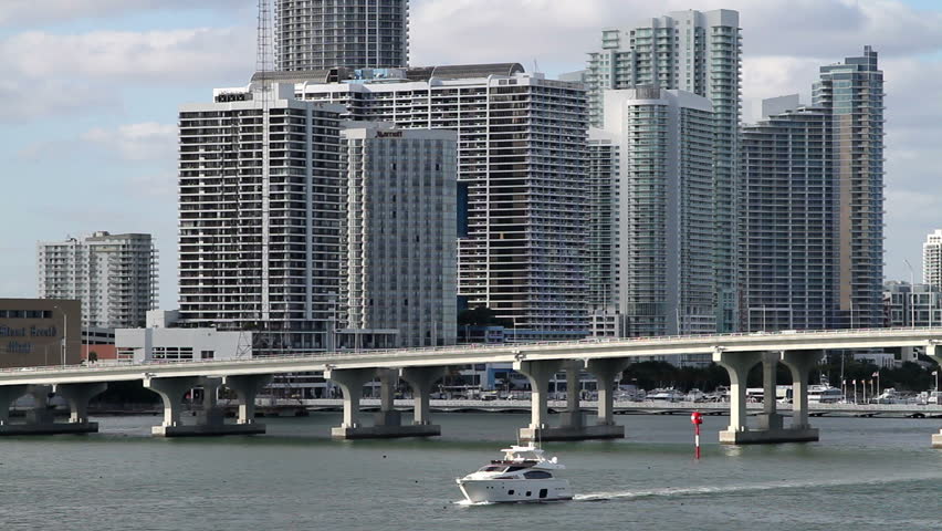 Cityscape, Miami skyline with bridge, from over the water angle. A boat enters