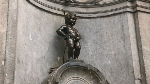 Brussels Belgium EUROPE 7 OCT 2016: close up video of the Manneken Pis or small peeing, pissing boy bronze sculpture, statue and fountain - is famous Bruxelles sightseeing travel landmark
