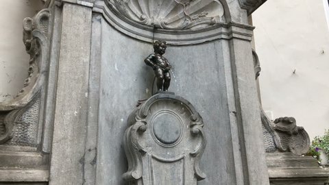 Brussels Belgium EUROPE 7 OCT 2016: pan tilt up camera motion video of Manneken Pis or small peeing, pissing boy bronze sculpture, statue, fountain is famous Bruxelles sightseeing, travel landmark