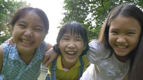 Slow motion shot : Group of little happy Asian girls playing together in the park