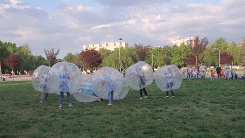 KRASNODAR, RUSSIA – MAY 1, 2016: The girls playing football inside the transparent zorb ball on the grass
