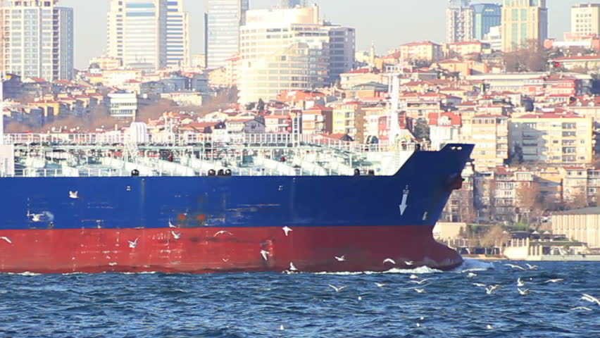 Oil tanker sails in front of the city. Bow of the large ship
