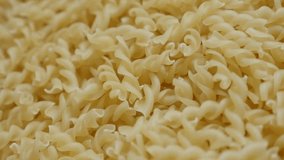 Spiral pasta falling on top close-up slow-mo 1920X1080 HD footage - Slow motion Italian food Girandole corkscrew shaped pasta pile on table1080p FullHD video