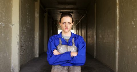 Portrait of Caucasian female welder standing with arm crossed in workshop