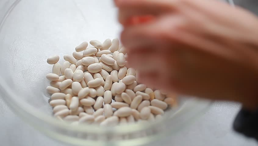 Woman cleans the house beans from the pods