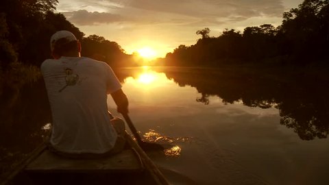 Paddeling With Canoe On The Amazon River in front of the sunset, South America, Peru