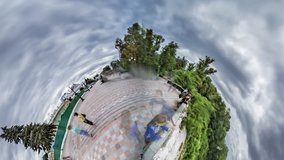 Tiny Little Planet 360 Degree Timelapse. Mariinsky Park. People at Observation Deck Are Looking Down at Kiev Sights. Aleys Are Made of Paving Tiles. Nature, Green Trees, Cloudy Day, Cloudscape.