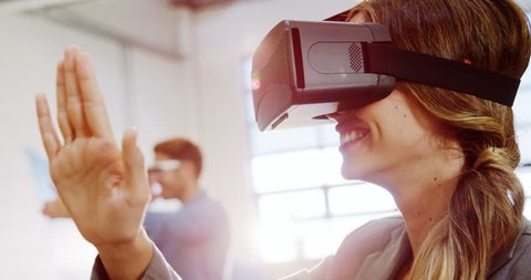 Female business executive using the virtual reality headset at office 4k