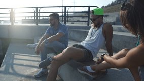 a group of hipsters with skateboards sitting on the waterfront