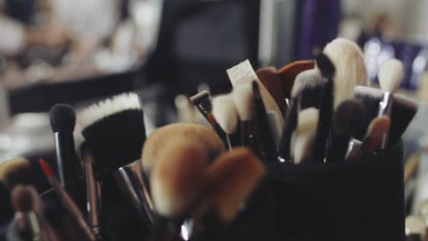 Set of brushes for make-up on table in dressing room. Fashion industry. Fashion show backstage.