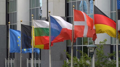European Union (EU) blue flag together with flags of the Euro countries - Bulgaria, Belgium, Czech Republic, Denmark, Germany at parliament building in Brussels, Europe.