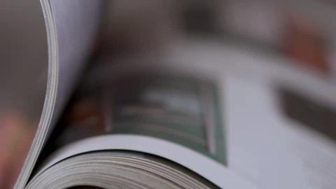 Magazine with open pages up close in man hands