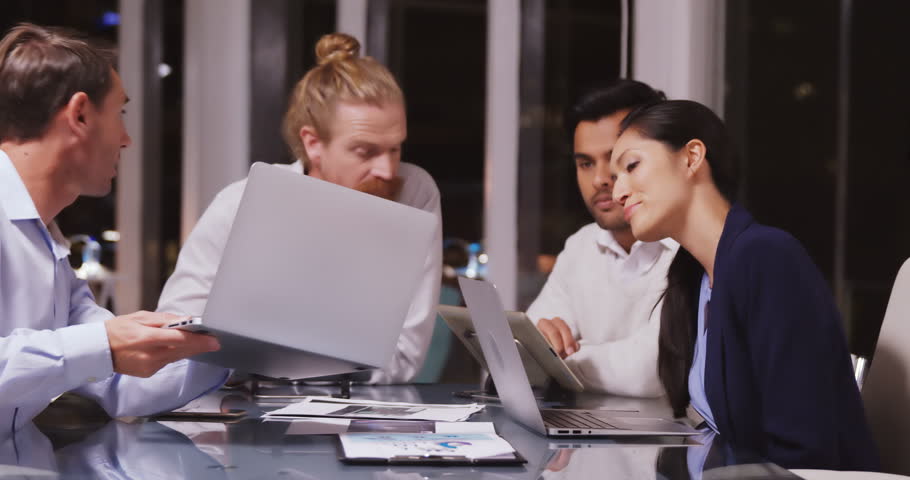 Business people discussing over laptop in office 4k